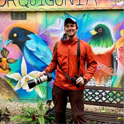 Image - Jason Fidorra in front of a colorful mural in Guatemala